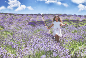 Pretty child girl runs in lavender field summer freedom concept