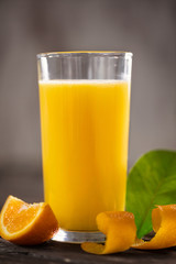 orange juice with orange slices on wooden table.