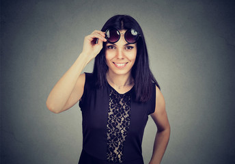 woman taking of sunglasses smiling looking at camera