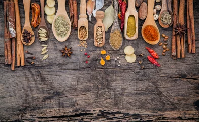 Photo sur Aluminium Herbes Various of spices and herbs in wooden spoons. Flat lay of spices ingredients chilli ,pepper corn, garlic, thyme, oregano, cinnamon, star anise, nutmeg, mace, ginger and bay leaves on shabby wooden.