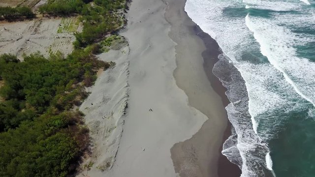 Beautiful aerial landscape footage of Parangtritis coastline with frothy wave in Yogyakarta, Indonesia. Shot in 4k resolution