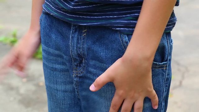 Closeup of hands of unhappy caucasian child. Child looking for money or something lost and shows his empty pockets of denim jeans. Real time full hd video footage.