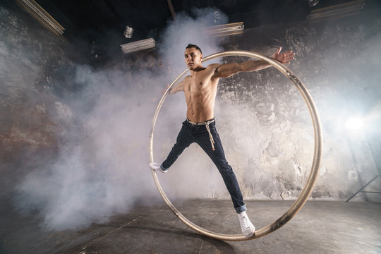 Strong circus performer spinning a cyr wheel
