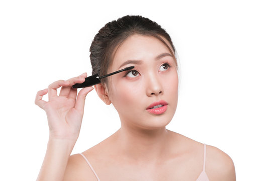 Portrait of a girl with a make-up brush for lash in hands isolated on white