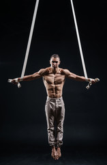 Fototapeta na wymiar circus artist on the aerial straps man