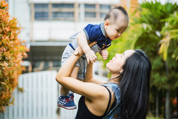 Naklejka premium portrait of asian mother and baby relaxing in the garden
