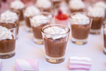 Tavolo buffet con bicchierini di dolci al cucchiaio in una cerimonia 