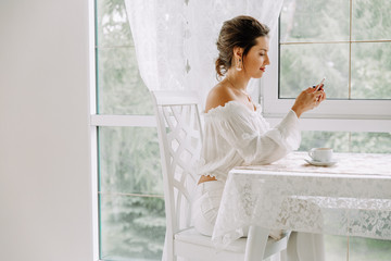 Woman using mobile phone in cafe. Female hand with smartphone and coffee.