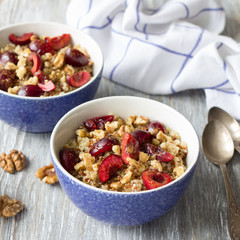 Healthy delicious vegan breakfast. Quinoa with fresh cherries, walnuts and honey on the blue background