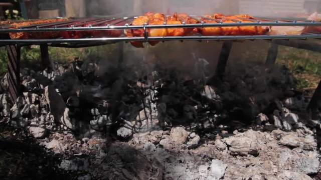 Detalle de varios tipos de carne y embutidos haciendose en la parrilla al aire libre 
