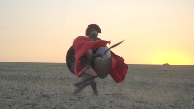Two gladiators learn to fight and defend themselves in the middle of the field, shooting before dawn. Slow motion