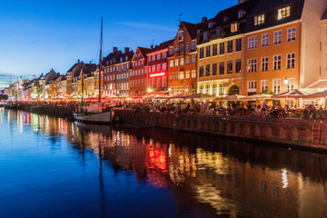 Obraz premium COPENHAGEN, DENMARK - AUGUST 27, 2016: Evening panorama of Nyhavn district architecture in the Old Town of Copenhagen, Denmark