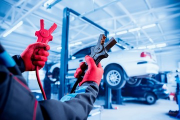 Accumulator charging. Hands and terminals. Car repair.