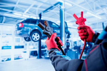 Accumulator charging. Hands and terminals. Car repair.