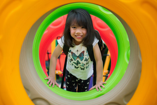 Asian kid fun and happy from play a donus ring in playgroung