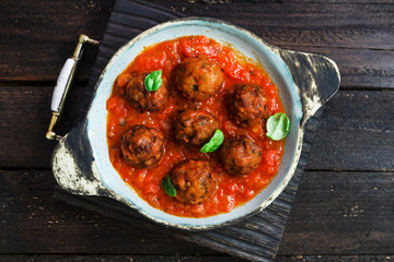 Meatballs with tomato sauce on a ceramic pan. Close view, rustic style