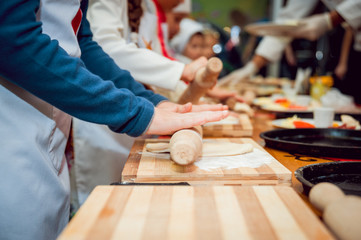 Fototapeta na wymiar Preparing pizza. Cooks hands and table close-up.