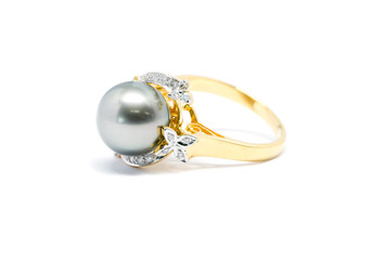 Closed up dark pearl with diamond and gold ring isolated