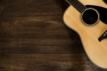 Naklejka premium Acoustic guitar on wooden background