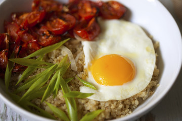 Savory quinoa with broiled tomatoes, green onions and sunny side up egg