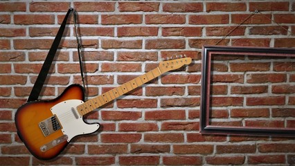 An electric guitar is hanging on a brick wall