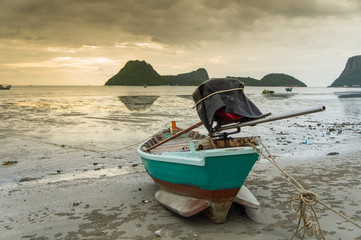 Obraz premium alone Fishing boat on the beach cloudy background