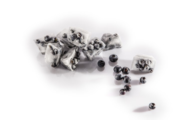 Beereneisw&uuml;rfel dekoriert mit Heidelbeeren auf wei&szlig;em Hintergrund