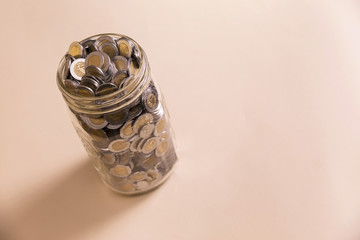 mexican pesos coins in glass jar with copy space
