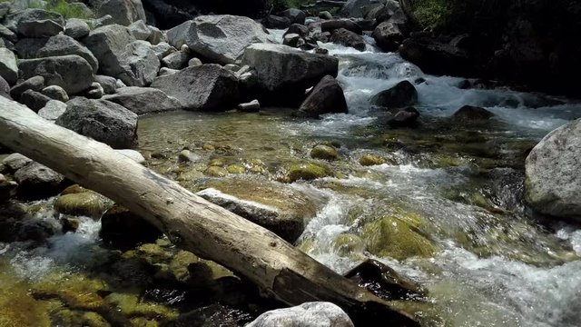 Aerial beautiful mountain stream river pull . Beautiful clear water mountain stream, springtime snow melt. Rocks and fallen timber logs in waterfalls. Forest nature in natural environment. Little Cott