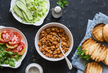Ingredients for cooking minced pork burger on dark background, top view, flat lay