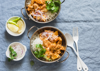 Vegetarian potato and cauliflower curry with rice in curry dishes on a blue background, top view. Vegetarian healthy food concept. Flat lay