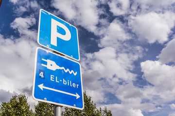 Parking lot for electric cars, sign against blue sky