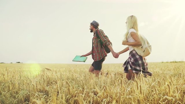 Happy couple walk throught the field