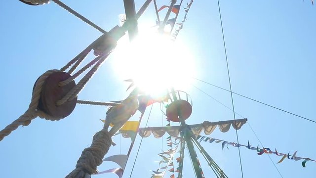 Sail mast is visible from below, the rays of the sun pass through the mast.