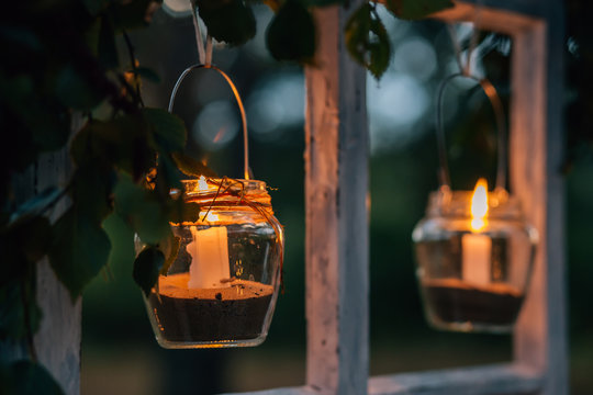 Lamps  with candles  are  hanging  on a tree at night. Wedding night decor.