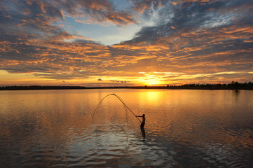 The silhouette fisherman and nets on during sunrise,Thailand