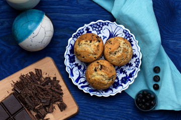 Schokomuffins auf blau gemustertem Teller und dunkelblauen Hintergrund 