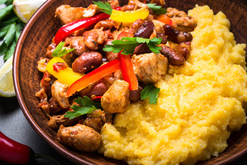 Corn porridge and meat with vegetables and beans in tomato.