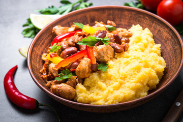 Corn porridge and meat with vegetables and beans in tomato.