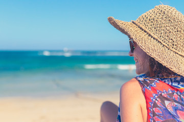 Summer holidays, vacation, travel and people concept - smiling young woman in sun hat on beach. Bali island, Indonesia.