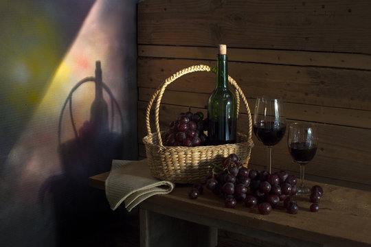 Still Life image of Fresh grapes and wine bottle in the brown basket with glass of wine