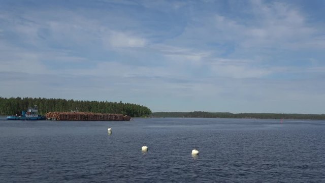 Barge with forest on lake Saimaa on a sunny summer day