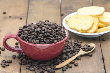 Obraz na płótnie Canvas coffee beans in a coffee cup on a wooden floor