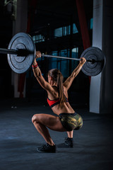 Naklejka na ściany i meble Muscular young fitness woman doing heavy deadlift exercise in crossfit gym