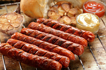 Grilled sausages with sauce ketchup and mustard on metal grate