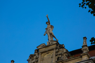 Statue of Mercury - a major Roman god standing on a building facade in city Lviv, Ukraine
