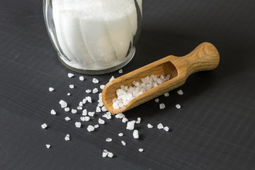salt crystals with wooden spoon and glass salt shaker