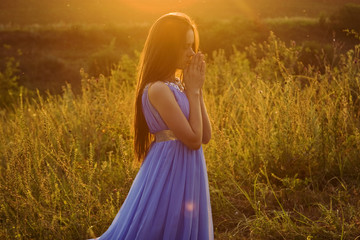 Obraz premium Beautiful, delicate girl at sunset to pray to the Almighty