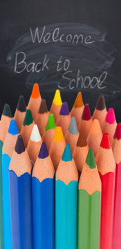 back to school pencils border on blackboard with welcome back o school text