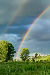 A beautiful rainbow over a farm field in New York. © ondreicka